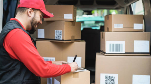 Happy courier with truck signing delivery of cardboard box on tablet - Focus on face