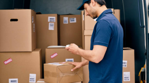 Courier checking packages in the trunk of a car